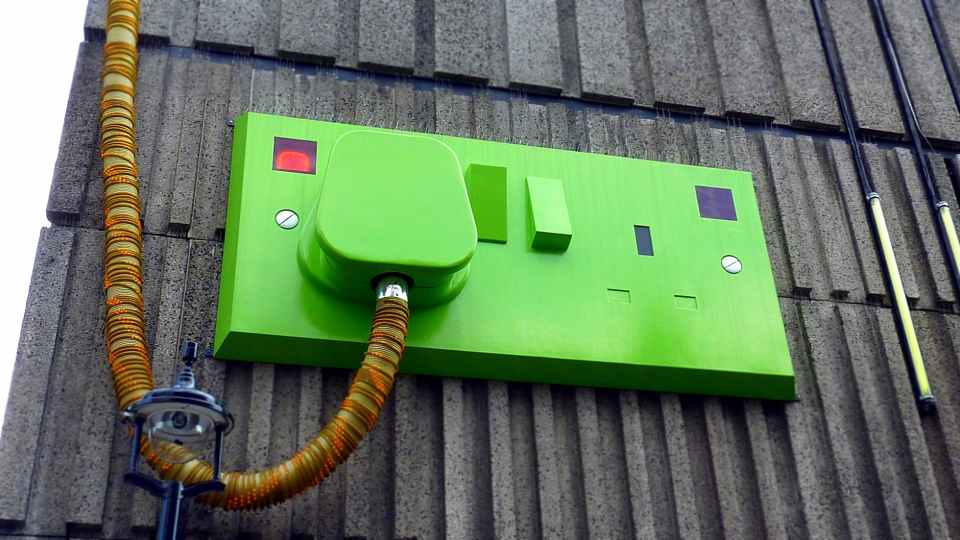 green rectangular corded machine on grey wall during daytime